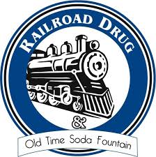 Logo for Railroad Drug with a vintage steam locomotive inside a blue circular border and a ribbon reading 'Old Time Soda Fountain' beneath it.