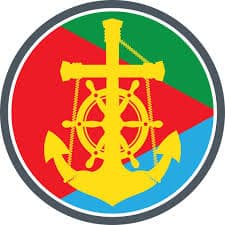 Circular maritime emblem featuring a yellow anchor and ship wheel intertwined with rope, set against a red, green, and blue color-block background within a dark ring.